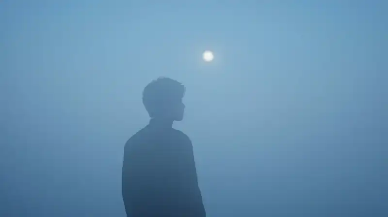 A fading silhouette dissolves into a vast, misty blue void