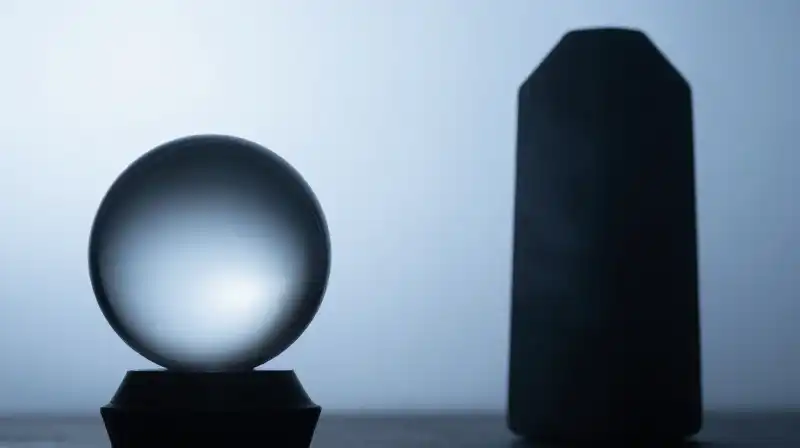 A glass sphere and stone monolith diverge in blue mist