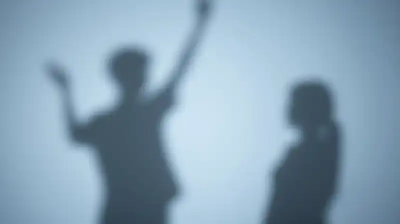 Two diverging shadows stretch across a soft, muted blue surface