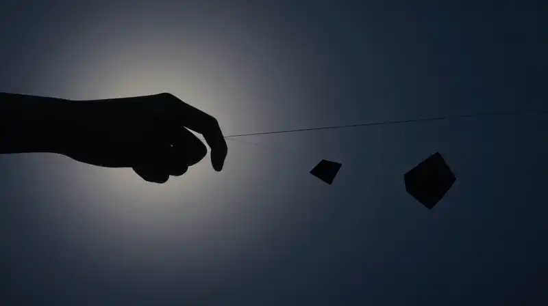 A shadowy hand pulls glowing threads amidst floating geometric shapes