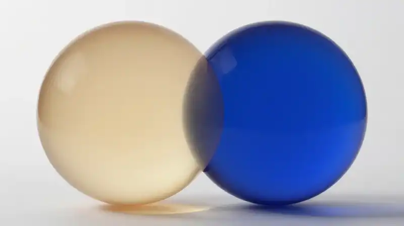 Two translucent spheres of amber and blue glow together