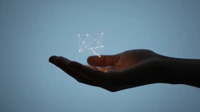 A steady hand offers delicate, glowing geometric threads into darkness