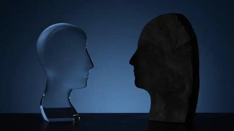 A fragile glass silhouette faces a solid stone monolith
