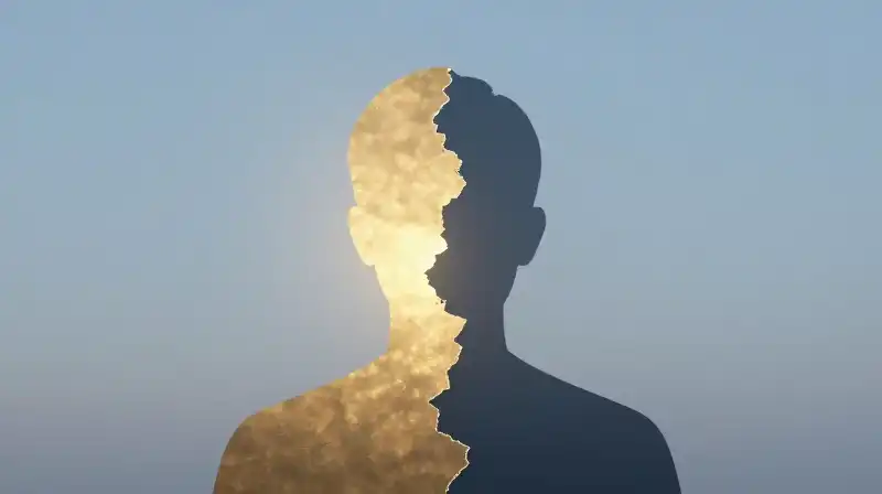 A split silhouette glows gold on one side, dissolving elsewhere