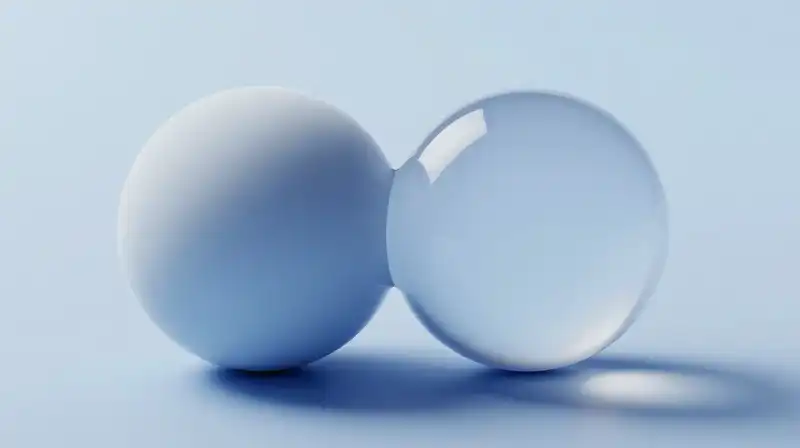 Two mirrored spheres, one solid and one shimmering, float together