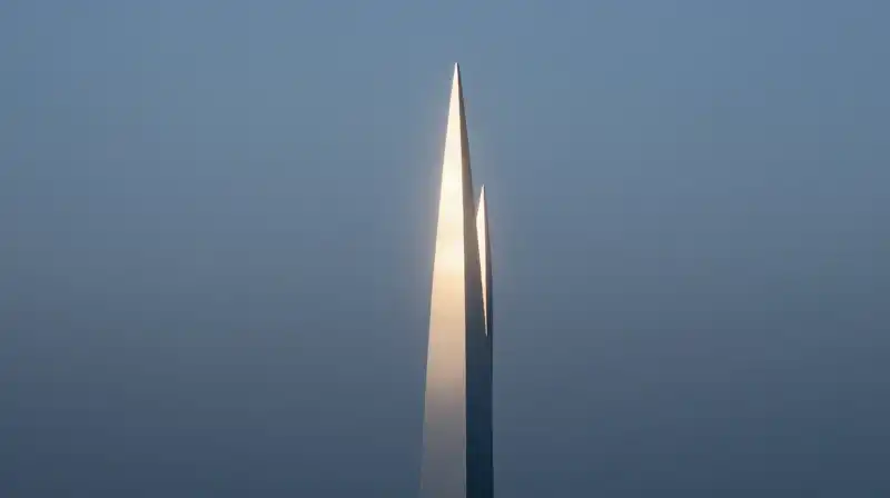 A glowing geometric monolith stands amidst calm blue mist