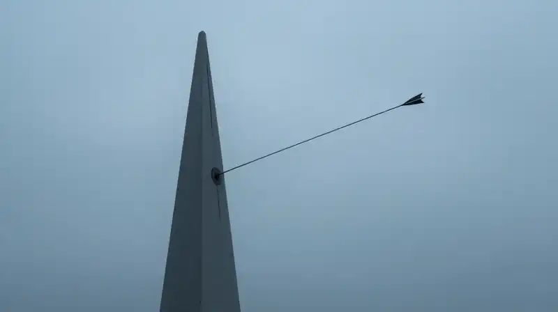 A sharp geometric monolith rises through a misty blue landscape