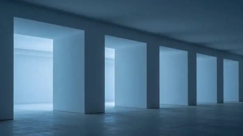 Monolithic geometric pillars stand within a minimalist blue space