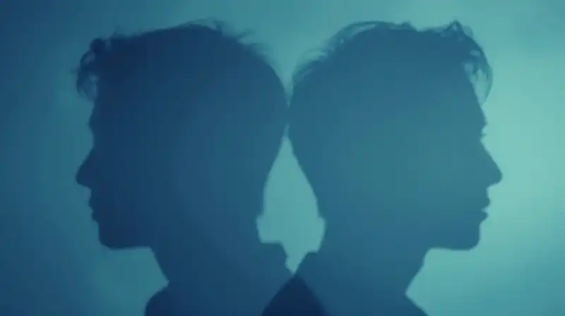 Two translucent, overlapping blue silhouettes drift in an ethereal space