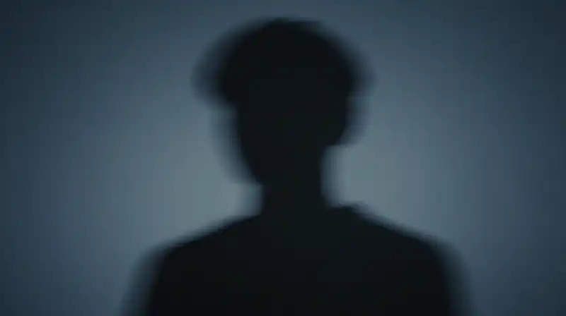 A fragmented silhouette shifts through deep blue geometric shadows