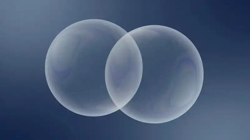 Two translucent, iridescent spheres overlap against a deep blue background