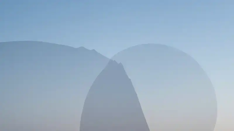 Two overlapping translucent shapes float in a soft blue void