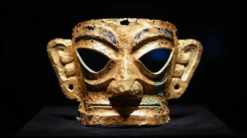 A gold mask crumbles to reveal a hollow blue core