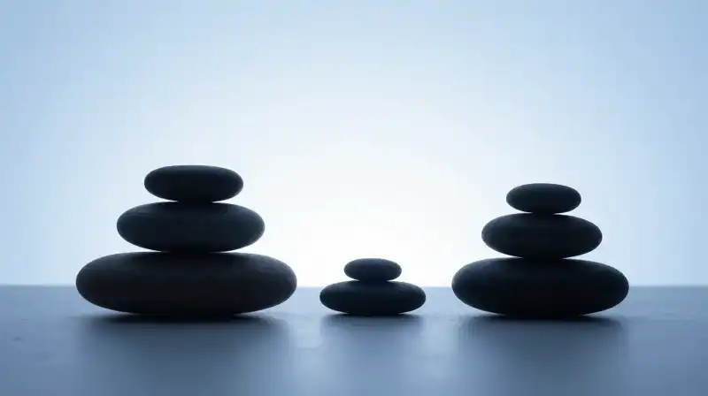 Balanced stone silhouettes sit in a calm, blue Zen garden