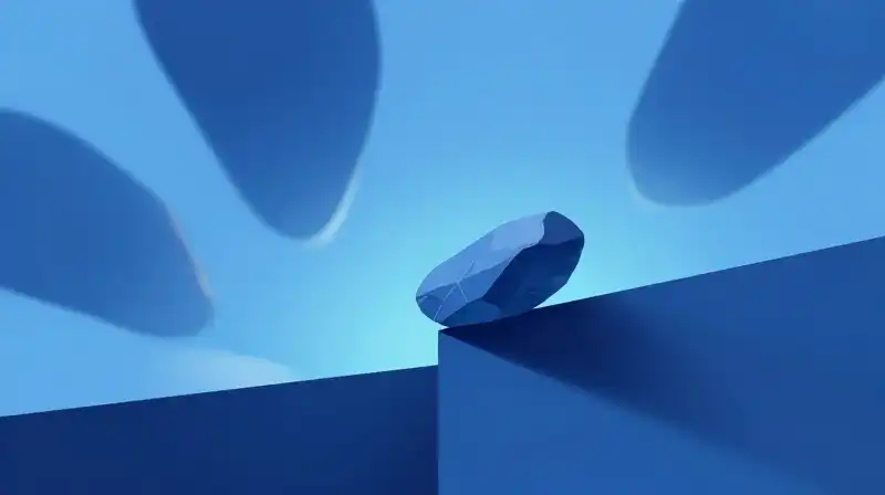 A single stone teeters on an edge amidst blue shapes