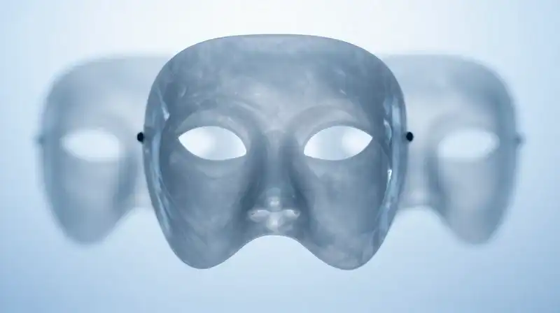 A polished crystalline mask hovers amidst translucent blue silhouettes