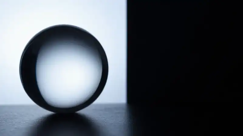 Two geometric silhouettes stand beside a fragile, glowing glass sphere