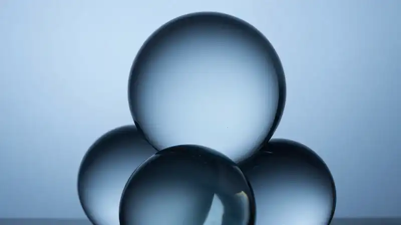 Translucent blue glass spheres overlap in deep, shadowy layers