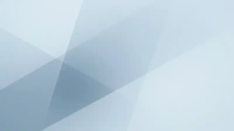 Translucent geometric shapes overlap amidst soft blue misty light