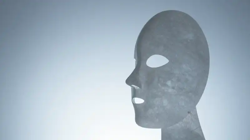 A translucent glass mask contrasts a solid stone silhouette