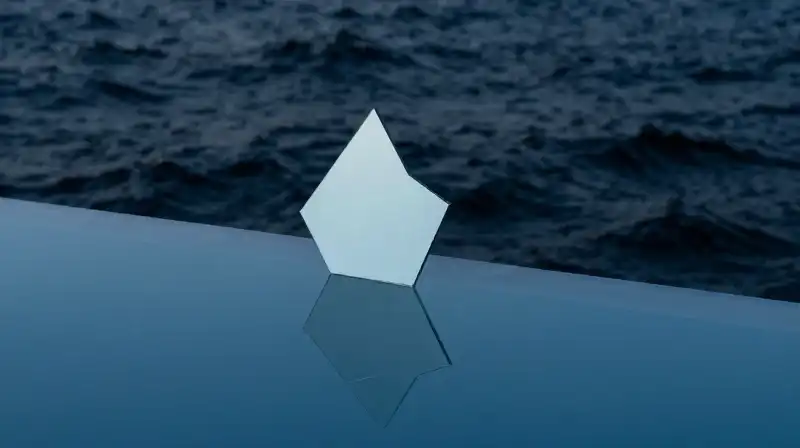 A fractured mirror silhouette splits calm blue and dark waves