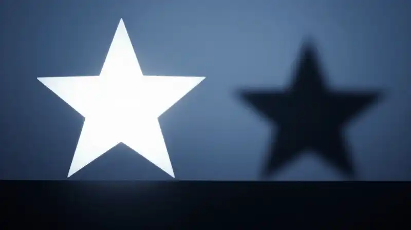 A bright star silhouette contrasts with a fading shadow